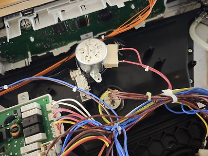 Innenansicht eines Elektrogeräts mit Kabeln und Platinen