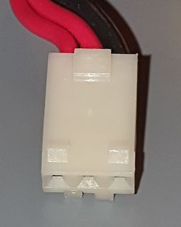 Weißer Kunststoffstecker mit roten und schwarzen Kabeln