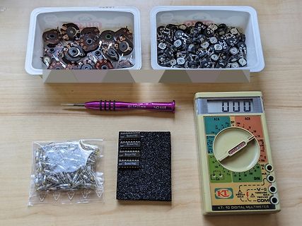 Elektronikbauteile, Multimeter und Werkzeug auf Tisch