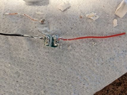 Lötstelle mit zwei Kabeln auf weißem Untergrund