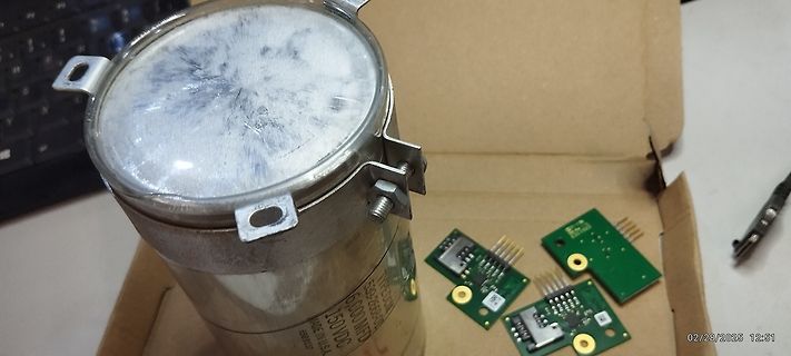 Großer Kondensator und kleine Leiterplatten in einem Karton
