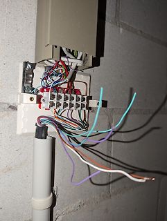 Offene elektrische Anschlussdose mit vielen bunten Kabeln