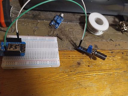 Breadboard-Aufbau mit Sensoren und Kabeln auf Holztisch