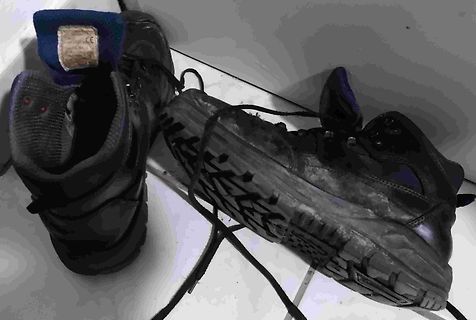 Zwei dunkle Schuhe auf Fliesenboden