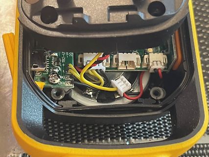 Innenansicht eines geöffneten gelben Elektronikgeräts mit Platine