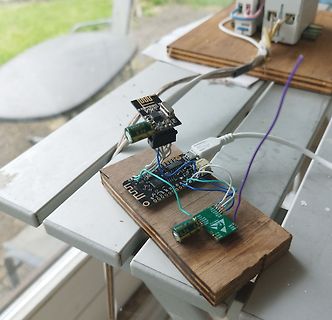Elektronik-Aufbau mit Mikrocontroller und Sensoren auf Holzbrett