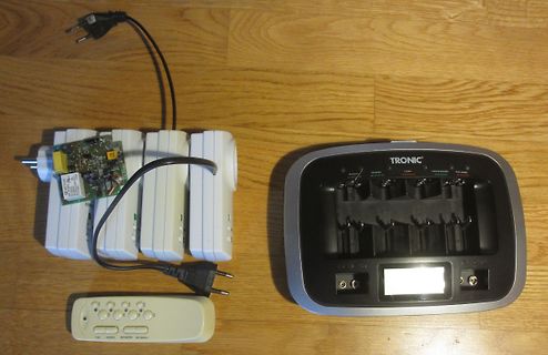 Batterieladegerät und Akkus auf Holzuntergrund