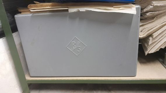 Graue Kunststoffbox mit Papierstapel auf Regal
