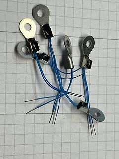 Mehrere Flachstecker mit blauen Kabeln und Ösen