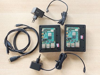 Zwei Raspberry Pi Boards mit Netzteilen und Kabeln