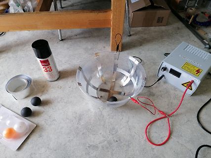 Versuchsaufbau mit Netzteil, Schüssel und Kontakt Spray