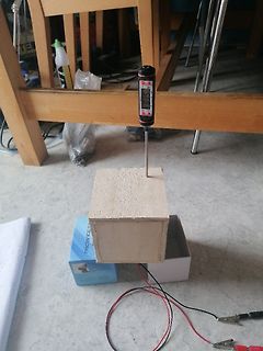 Digitales Thermometer auf Holzblock mit Kabeln