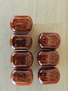 Sechs bernsteinfarbene elektronische Bauteile auf Holzuntergrund