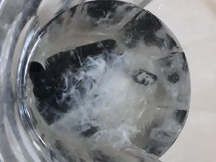 Nahaufnahme einer unklaren, weißlichen Substanz in einem Glas