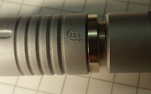 Nahaufnahme eines metallischen Bauteils mit Logo