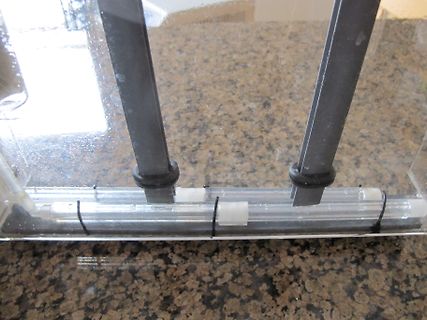 Nahaufnahme eines transparenten Bauteils mit schwarzen Halterungen