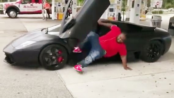 Mann fällt gegen schwarzen Sportwagen an Tankstelle