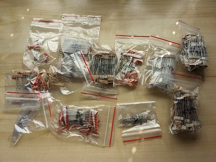 Mehrere kleine Plastiktüten mit elektronischen Bauteilen auf Holztisch