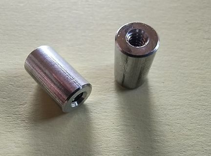 Zwei metallische Distanzhülsen mit Innengewinde