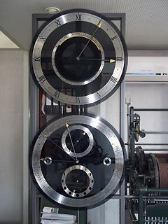 Zwei große mechanische Uhren an einer Wand