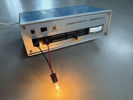 Labornetzteil mit leuchtender Glühbirne