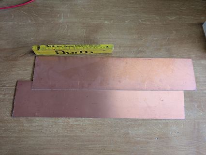 Kupferstreifen und Lineal auf Holztisch