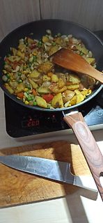 Pfanne mit Bratkartoffeln und Gemüse auf Induktionskochfeld