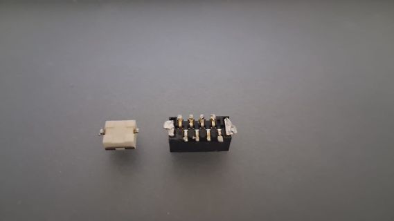 Zwei elektronische Steckverbinder auf grauem Untergrund
