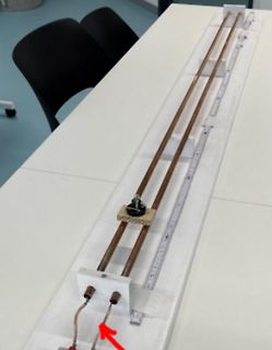Versuchsaufbau mit Schienen und Messskala