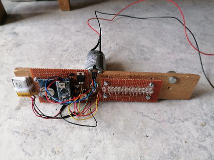 Elektronik-Aufbau auf Holzbrett mit Arduino und Motor