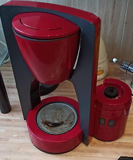 Rote Kaffeemaschine auf Holztisch