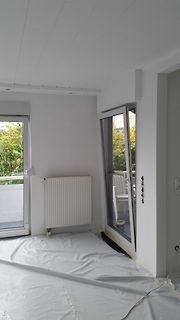 Innenansicht eines leeren Raumes mit Balkontüren