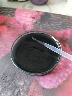 Dunkle Flüssigkeit in einer Petrischale mit Pipette