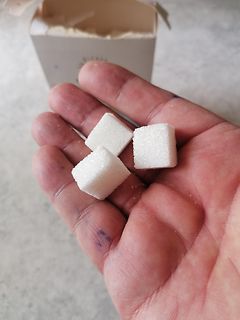 Drei Zuckerwürfel in einer Hand