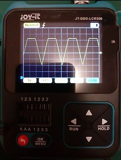 Abfotografiertes Handheld-Oszilloskop mit Sinuswelle