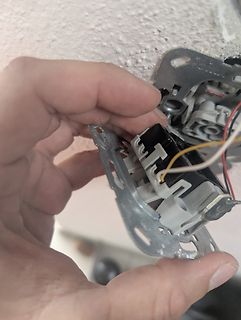 Hand hält eine Lichtschalter-Konstruktion