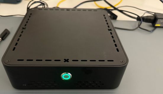Schwarzer Mini-PC mit grün leuchtendem Power-Button