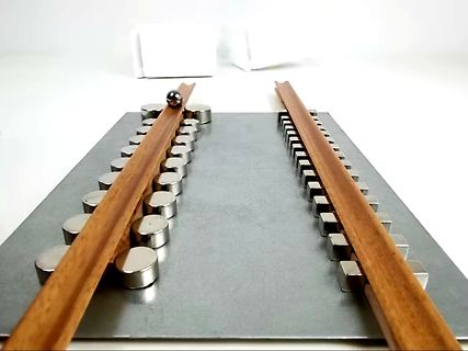 Experimenteller Aufbau mit Magneten und Metallkugel