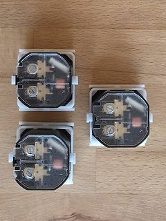 Drei elektrische Steckkontakte auf Holzuntergrund