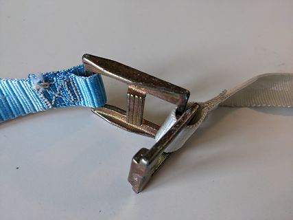Metallschließe an einem blauen Gurtband