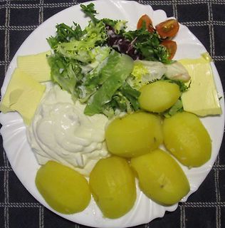 Teller mit Kartoffeln, Salat und Dip