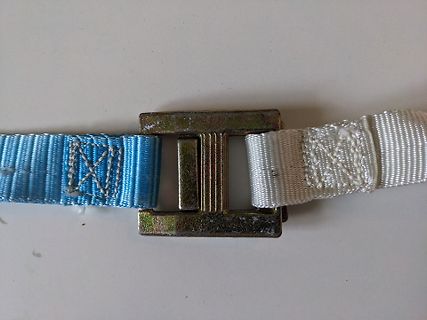 Metallschließe an blauem und weißem Gurtband