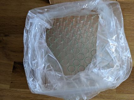 Transparente Plastiktüte mit kreisförmigen Mustern auf Holzuntergrund