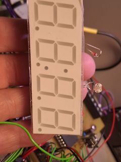 Hand hält 4-stelliges 7-Segment-Display vor Platine
