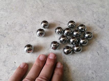 Silberne Metallkugeln auf einer hellen Oberfläche