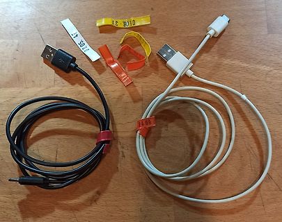 USB-Kabel und beschriftete Klebestreifen auf Holzuntergrund
