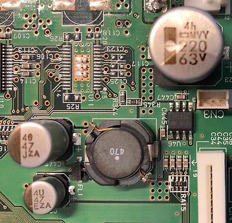 Nahaufnahme einer bestückten Leiterplatte mit Elektrolytkondensatoren und Induktivität