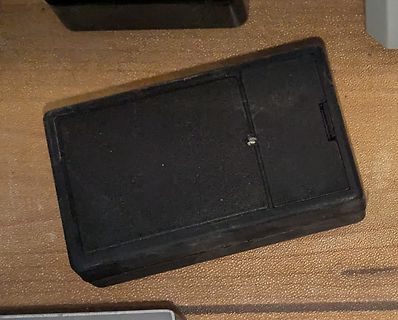 Schwarzes Kunststoffgehäuse auf Holzoberfläche