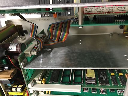 Innenansicht eines elektronischen Geräts mit Leiterplatten und Flachbandkabel