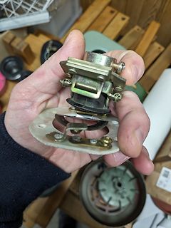 Hand hält zerlegtes elektrisches Bauteil